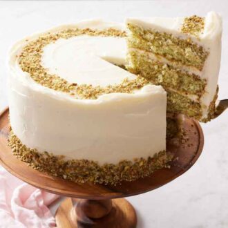A slice of pistachio cake lifted from the cake.
