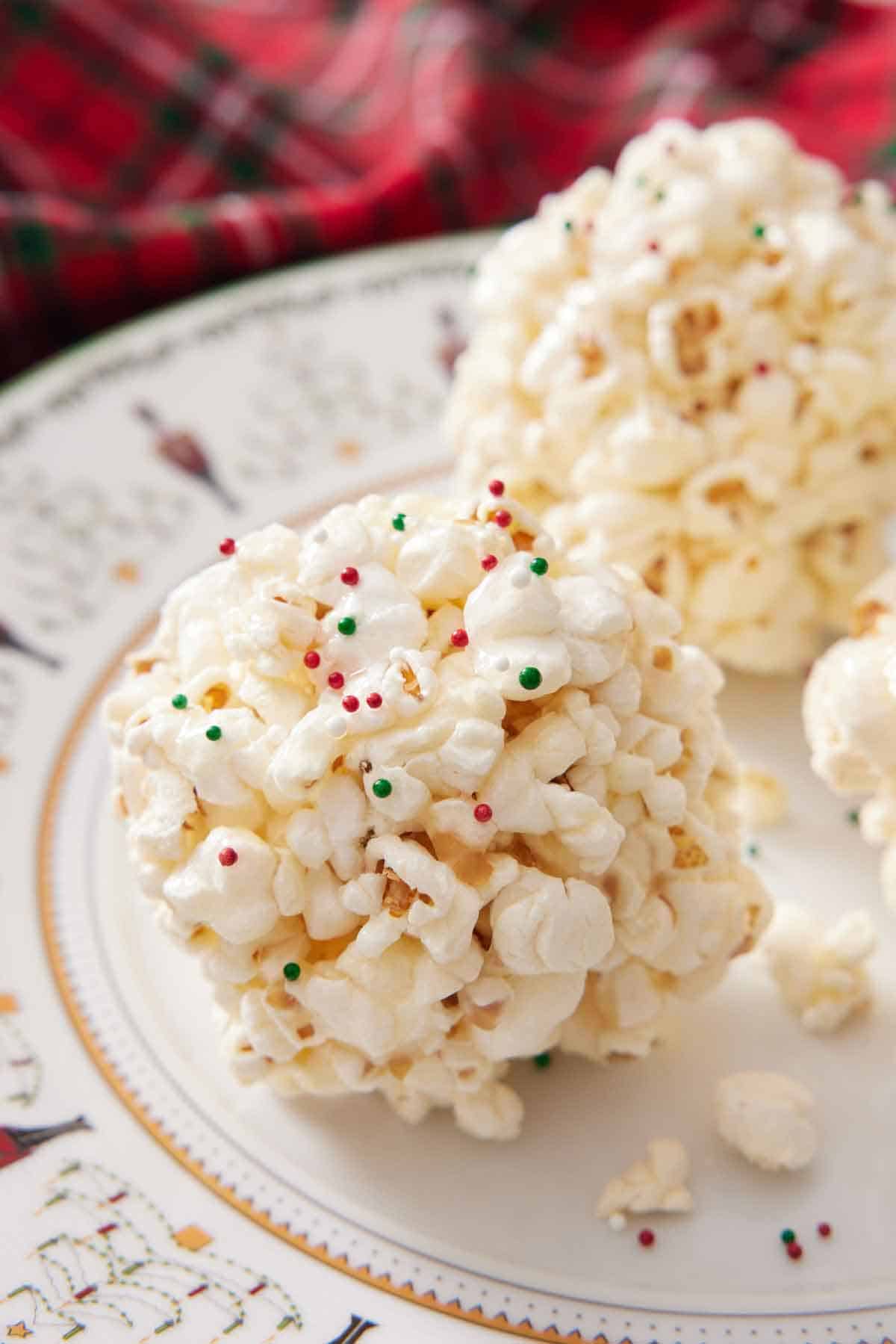 A popcorn ball in a plate with green and red sprinkles.
