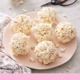 Pinterest graphic of a plate with six popcorn balls. A packaged popcorn ball in the background.