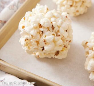 Pinterest graphic of popcorn balls on a lined sheet pan.