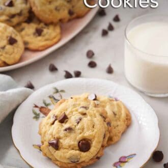 Pinterest graphic of a plate with a pudding cookie and in the back there's a glass of milk and a platter of cookies.