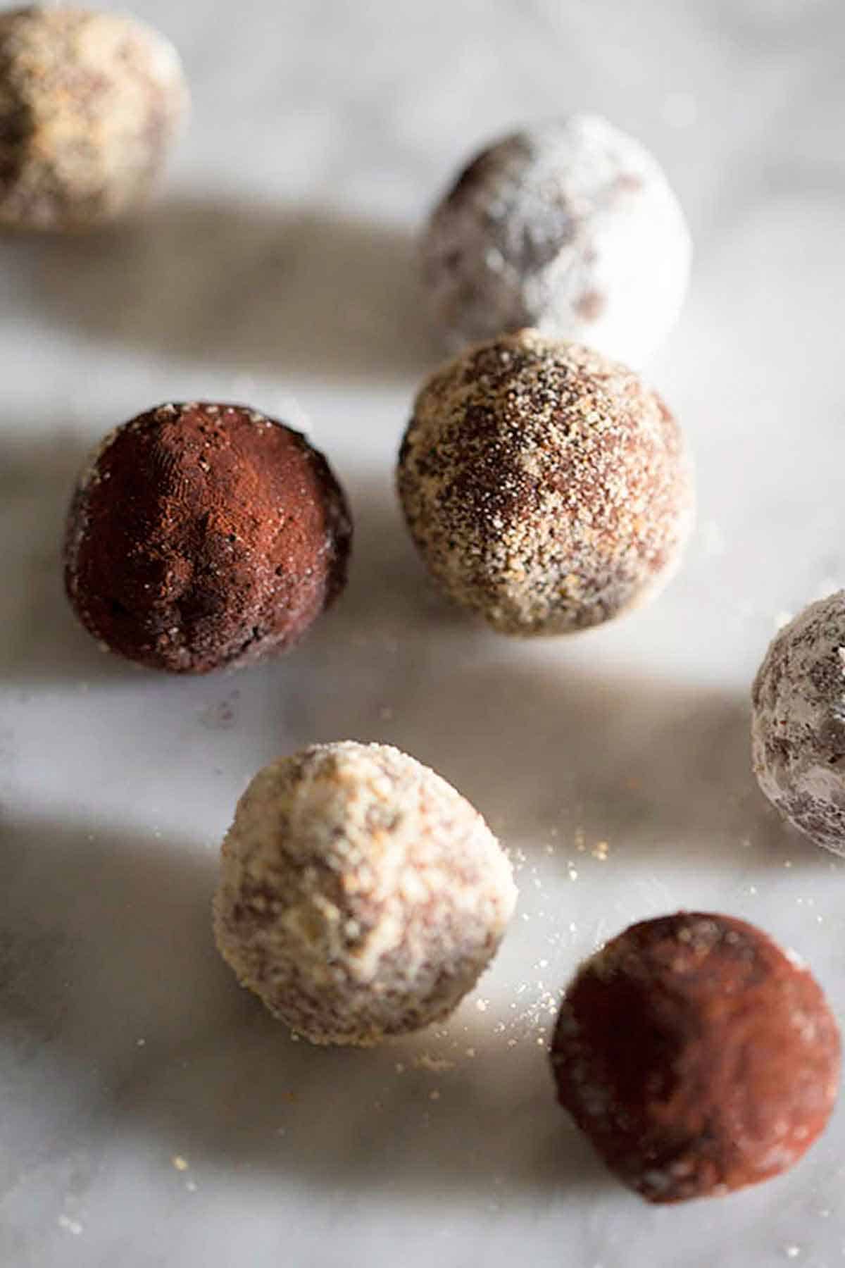 Multiple rum balls on a marble counter.