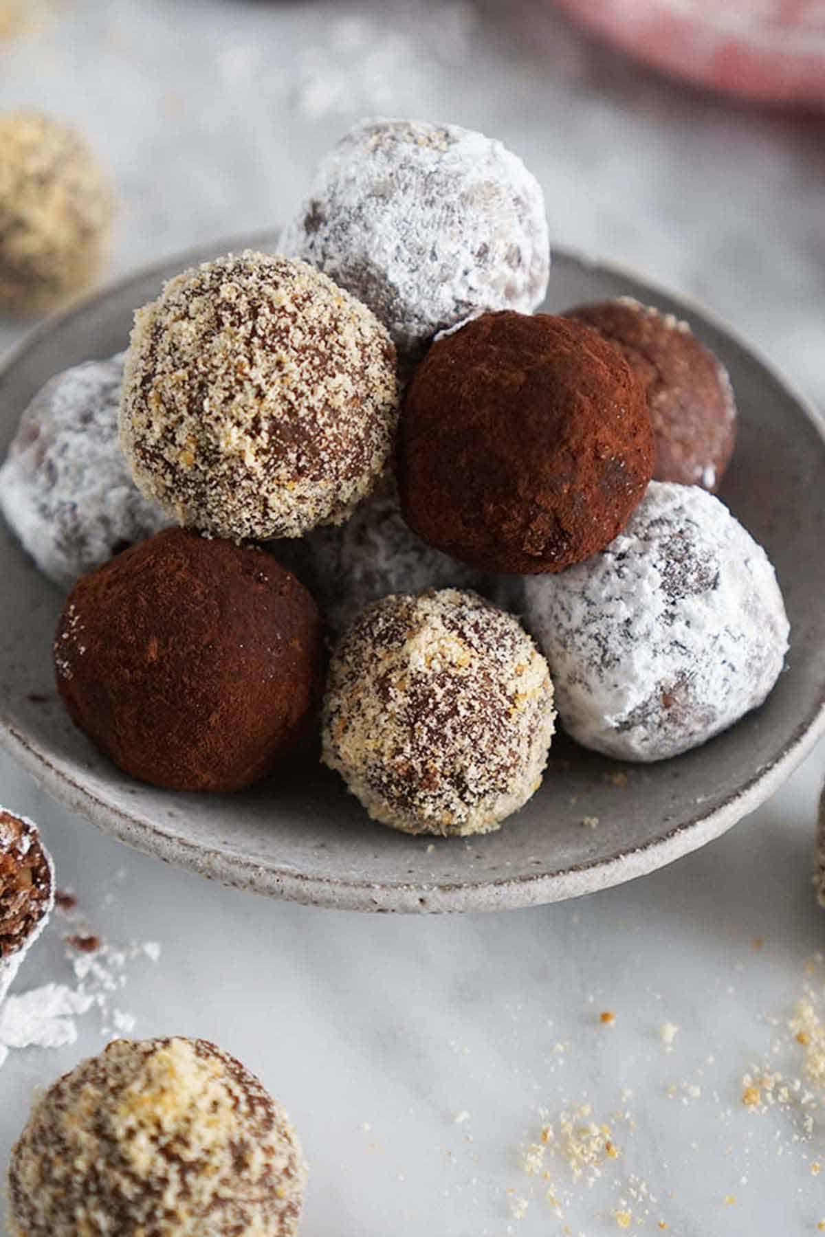 A plate of rum balls with an assortment of coatings.