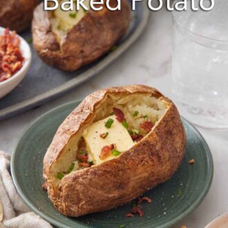 Pinterest graphic of a plate with an air fryer baked potato topped with butter, chives, and crumbled bacon with more potatoes in the background.