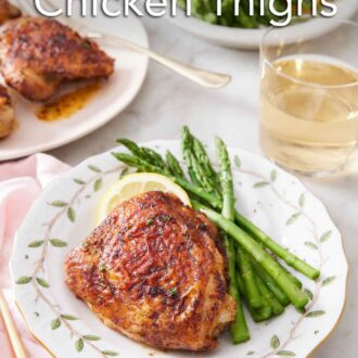 Pinterest graphic of a plate with an air fryer chicken thigh, asparagus, and a lemon slice with more thighs, a glass of wine, and asparagus in the background.