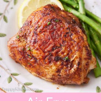 Pinterest graphic of an air fryer chicken thigh on a plate with lemon and asparagus.