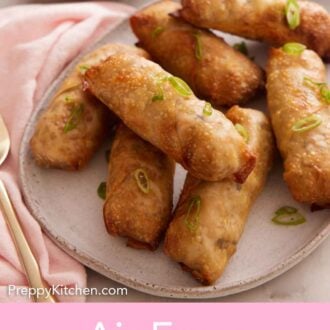 Pinterest graphic of a platter of air fryer egg rolls garnished with green onions with a small bowl of dipping sauce in the background.