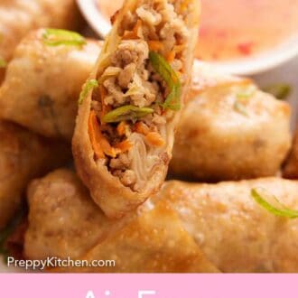Pinterest graphic of half an air fryer egg roll on top of a platter of more rolls.