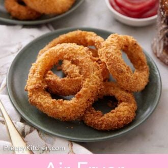 Pinterest graphic of a plate of air fryer onion rings with a second plate in the back with some ketchup.