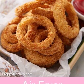 Pinterest graphic of a platter of air fryer onion rings with a small bowl of ketchup.