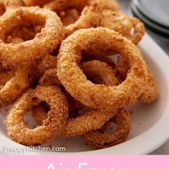 Pinterest graphic of a white platter of air fryer onion rings with ketchip in the background.