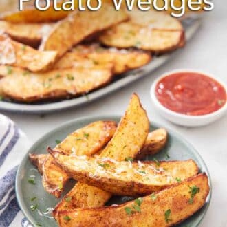 Pinterest graphic of a plate of air fryer potato wedges topped with grated parmesan and parsley with a platter more in the background with a bowl of ketchup.