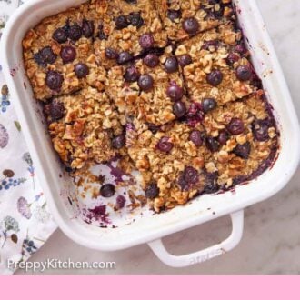 Pinterest graphic of a white baking dish with baked oatmeal cut into nine pieces with one removed.