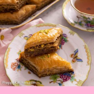 Pinterest graphic of a plate with two pieces of baklava with a cup of tea and tray of more baklava in the background.