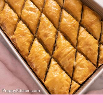 Pinterest graphic of a baking dish with cut baklava.