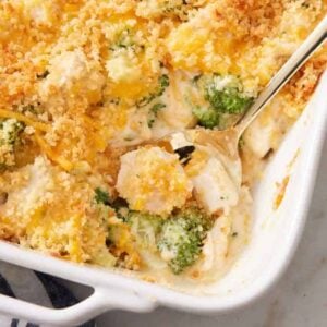A baking dish of chicken divan with a spoon scooping some out.