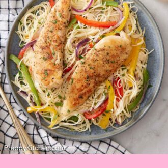 Pinterest graphic of a plate of chicken scampi with two chicken tenderloins on top.