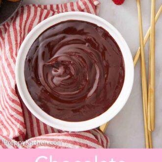 Pinterest graphic of an overhead view of a bowl of chocolate fondue with long forks and strawberries beside it.