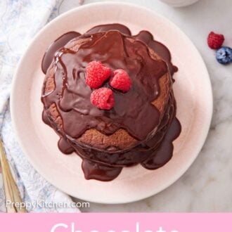 Pinterest graphic of an overhead view of a stack of chocolate pancakes with chocolate sauce and raspberries.