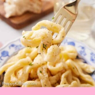Pinterest graphic of a fork lifting up strands of egg noodles from a plate.