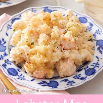 Pinterest graphic of a plate of lobster mac and cheese with a glass in the background.