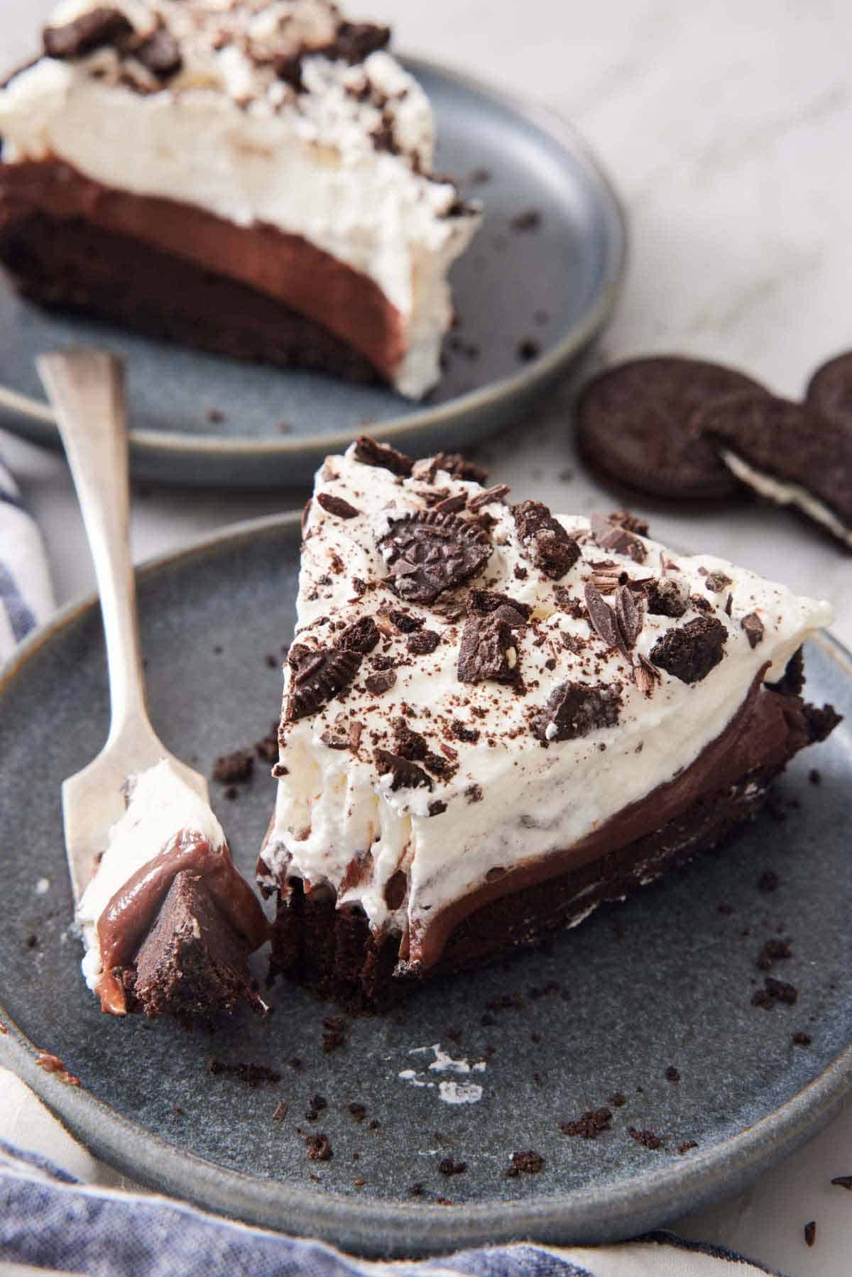 A slice of mud pie on a plate with the tip on a fork beside it.