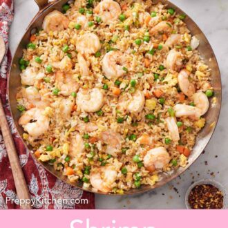Pinterest graphic of an overhead view of a skillet of shrimp fried rice with some red pepper flakes and soy sauce off to the side.