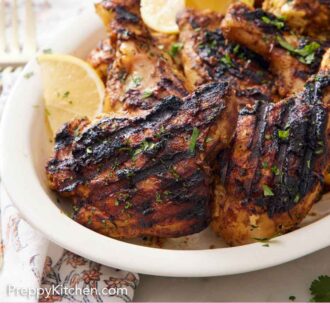 Pinterest graphic of a platter of tandoori chicken with lemon wedges.
