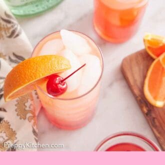 Pinterest graphic of an overhead view of two glasses of tequila sunrises with orange slices and maraschino cherries as garnish. A bottle of tequila beside it.