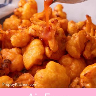 Pinterest graphic of buffalo sauce poured over air fried cauliflower.