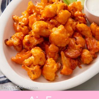 Pinterest graphic of a platter of air fryer buffalo cauliflower with dip and celery sticks.