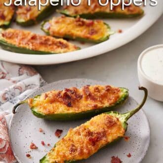 Pinterest graphic of a plate with two air fryer jalapeno poppers with more in a platter in the background.