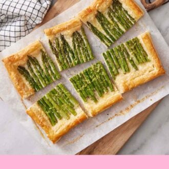 Pinterest graphic of an overhead view of a sliced asparagus tart on a sheet of parchment over a wooden serving board.