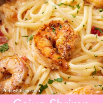 Pinterest graphic of a close up view of cajun shrimp pasta with chopped parsley garnish.