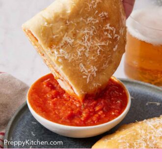 Pinterest graphic of half a calzone dipped into a bowl of pizza sauce.