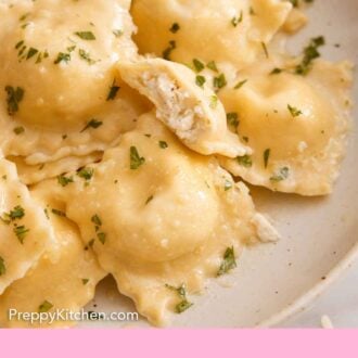 Pinterest graphic of a close up view of a plate of cheese ravioli garnished with chopped herbs. One ravioli bitten in half, showing the cheese filling.