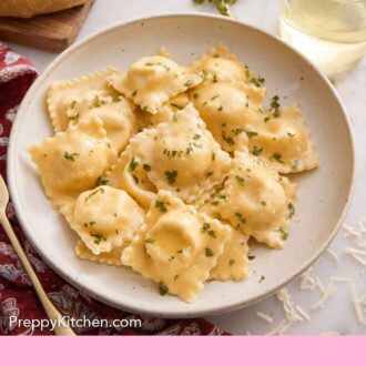 Pinterest graphic of cheese ravioli topped with chopped herbs with a glass of wine, parsley, and bread in the background.