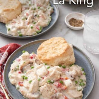 Pinterest graphic of two plates of chicken a la king with biscuits. A glass of water and a bowl of pepper off to the side.