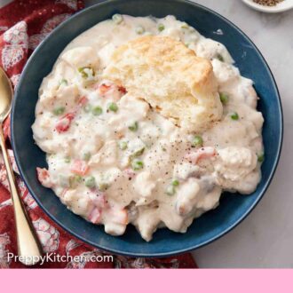 Pinterest graphic of an overhead view of a bowl of chicken a la king with half a biscuit on top.