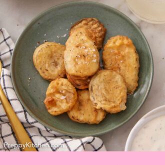 Pinterest graphic of a green bowl of fried pickles topped with flaky salt. Drink and bowl of sauce off to the side.