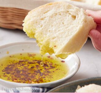 Pinterest graphic of a piece of Italian bread dipped into oil with more bread in a basket in the back.