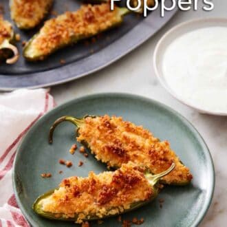 Pinterest graphic of a plate with two jalapeno poppers with a bowl of dipping sauce on the side. A platter with more jalapeno poppers in the background.