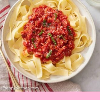 Pinterest graphic of marinara sauce on top of a bowl of cooked pasta noodles.