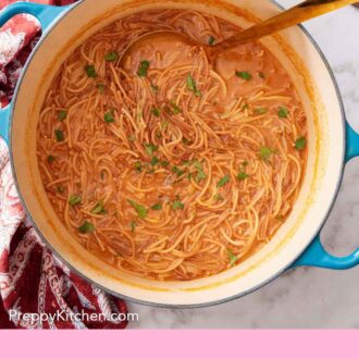 Pinterest graphic of a dutch oven with sopa de fideo topped with cilantro with a ladle inside.