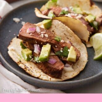 Pinterest graphic of a close up view of a steak taco on a plate with a second one behind it.
