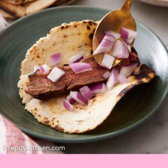Pinterest graphic of diced red onions spooned onto a tortilla with steak.
