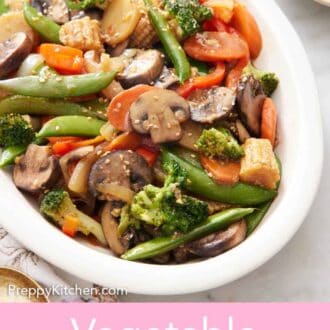Pinterest graphic of a white platter of vegetable stir fry with a bowl of sauce in the back.