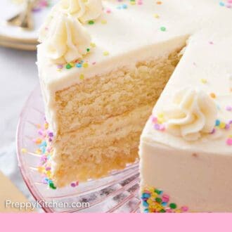 Pinterest graphic of a white cake on a cake stand with a slice taken out so you can see the layers in the cake.