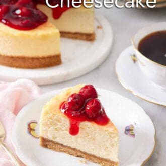 Pinterest graphic of a plate with a slice of air fryer cheesecake with cherry sauce on top. The rest of the cheesecake in the background along with a mug of coffee.