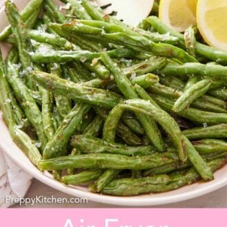 Pinterest graphic of a plate of air fryer green beans with a fork by two lemon wedges.